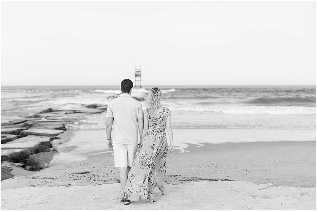 Black and white photo of Don and Val holding hands while they look out at the ocean together.