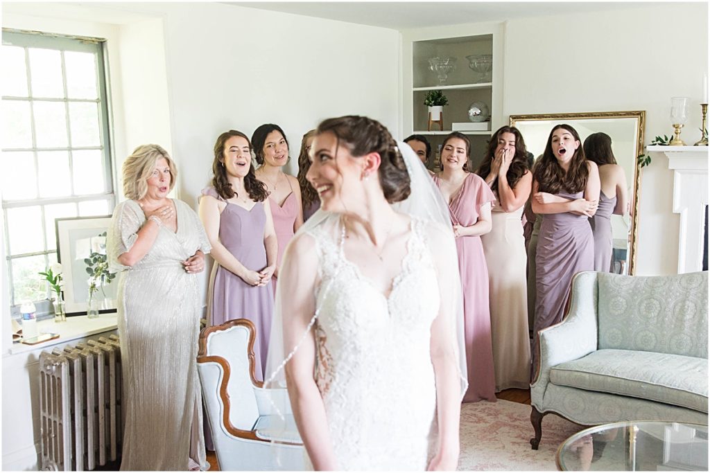 The mom of the bride and the bridesmaids reacting to Gabby in her dress