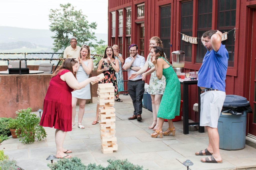 family and friends playing giant jenga during Katie and Wesley's rehearsal dinner 