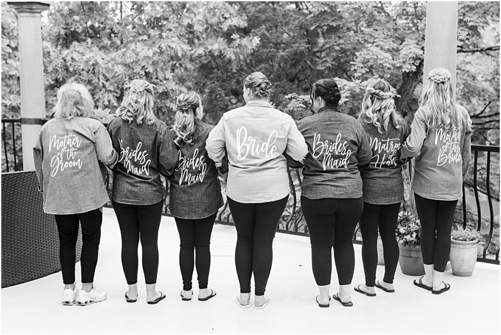 The bride and her bridesmaids standing with their back to the camera in their custom shirts.