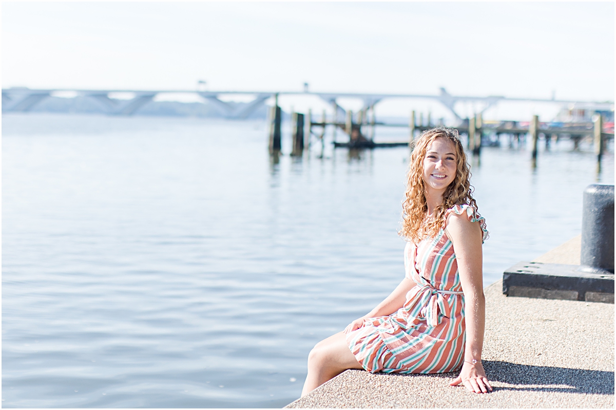 Amanda sitting on a dockside with the water in the background; photo taken by a photographer in Virginia.