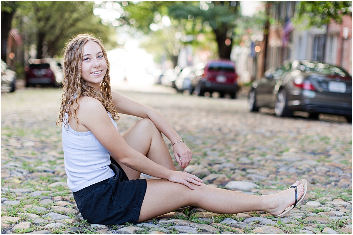 Amanda sitting on an old road in Old Town Alexandria 